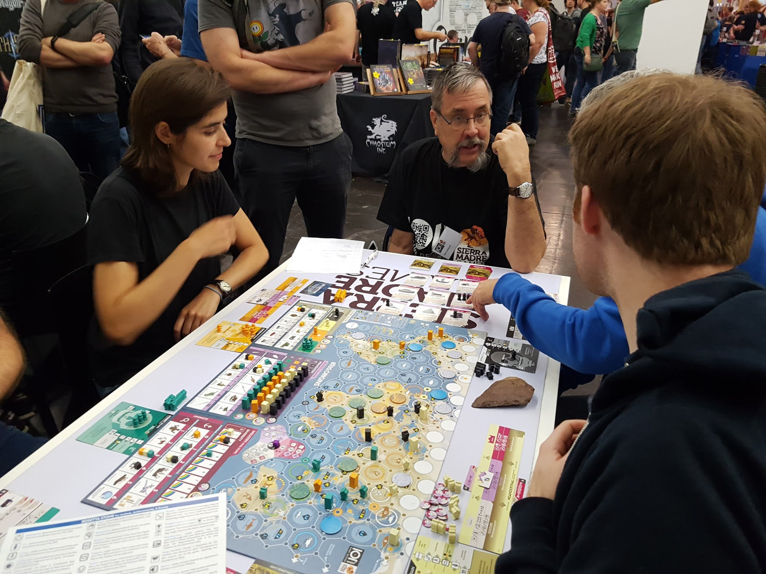 Four people around a table playing a board game.