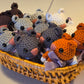 Basket filled with crocheted mouse toys in various colors.