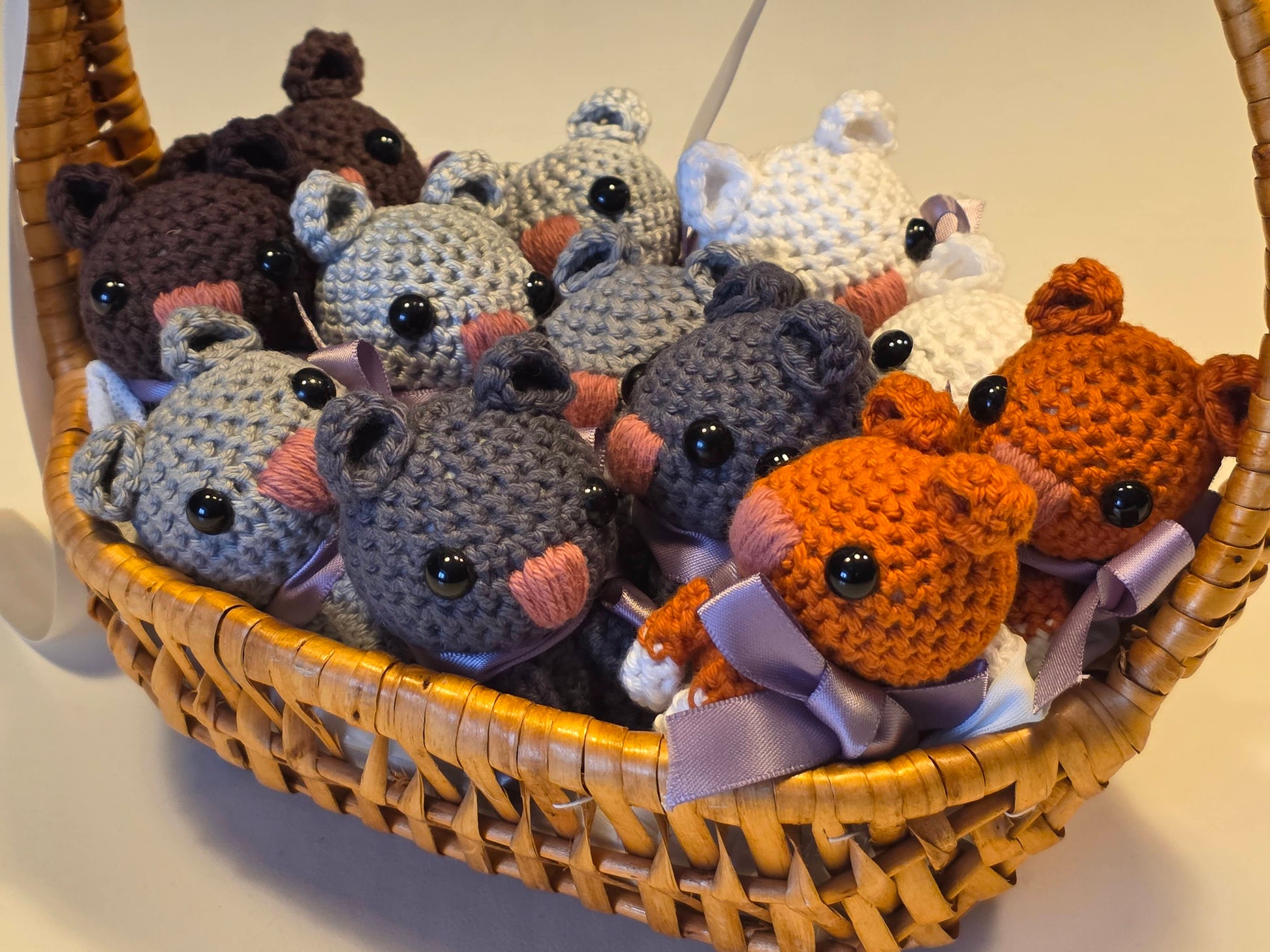 Basket filled with crocheted mouse toys in various colors.