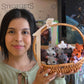 Woman holding a basket with small animal plush toys in front of a store interior.