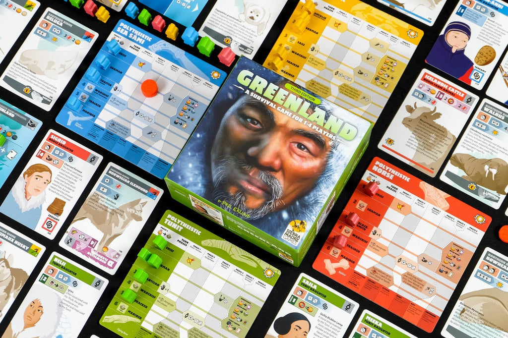 Greenland board game box, playing cards, and figurines organized next to each other