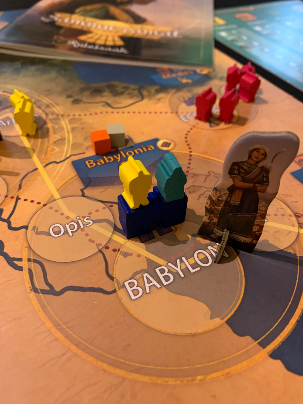 Sammu-Ramat Board Game - Close up view of the empire meeples, and punchout characters displayed on the board